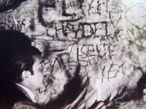 Otto Rahn looking a graffiti in a cave